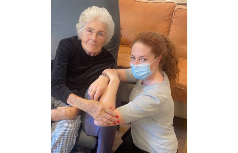 Kelly Haddock, Trainee Nurse Associate at Belong Atherton, with a resident