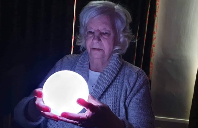 Ann Black, 78, resident at Belong Crewe, inspects a moon lamp as part of the Astronomy Club's activities