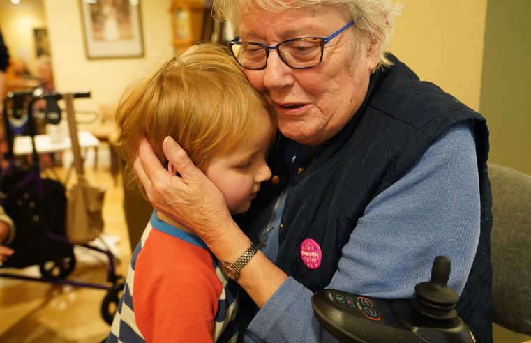 RAF veteran Vera, gets a hug during the visit to Royal Star & Garter from Child’s Play Nursery.(Image credit: Royal Star & Garter)